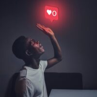 man in white crew neck top reaching for the like