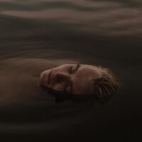 a man in the water with his eyes closed
