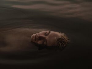 a man in the water with his eyes closed
