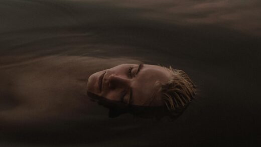 a man in the water with his eyes closed